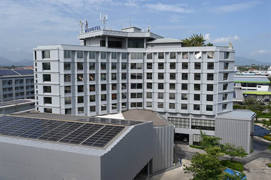 A mid-rise hotel with solar panels on its roof
