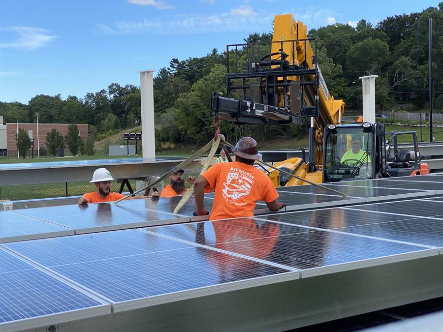 An installation crew fixing solar panels on a roof