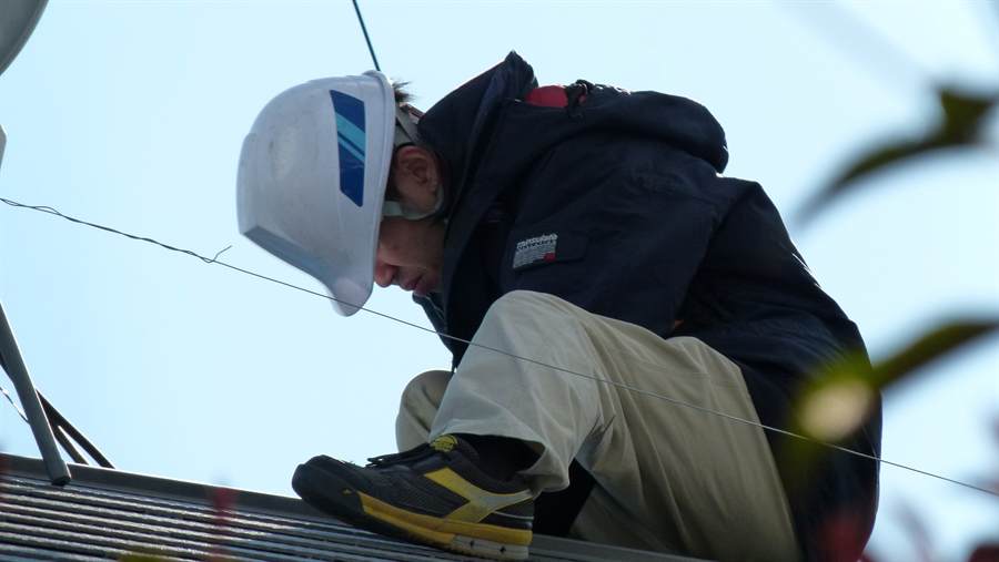 A technician working on rooftop solar panels